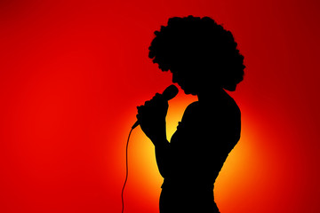 Silhouette of singing woman with microphone