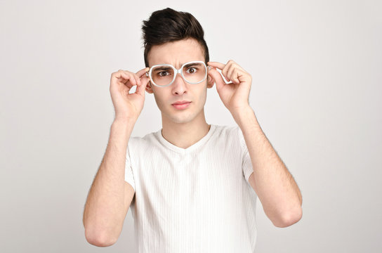 Confused, disturbed, upset.Young man with glasses frowning.
