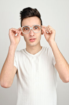 Surprised, amazed, confused.Young man with funny glasses.