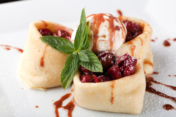 Rolled pancakes with cherry and ice cream