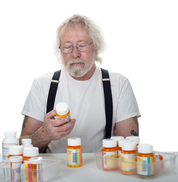 Senior Looking At A Bottle Of Pills