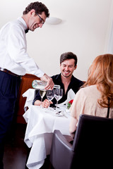 Mann und Frau werden im Restaurant vom Kellner bedient