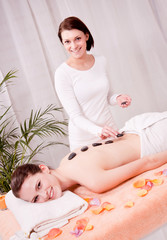 Obraz na płótnie Canvas attraktve młoda kobieta dostaje masaż gorącymi kamieniami