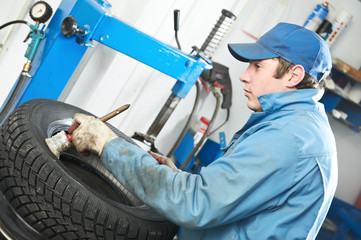 repairman mechanic lubricating car tyre