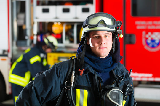 Feuerwehrmann steht in Uniform vor einer Feuerwehr