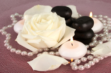 Fototapeta na wymiar kamienie spa z kwiatów i świec w wodzie na talerzu