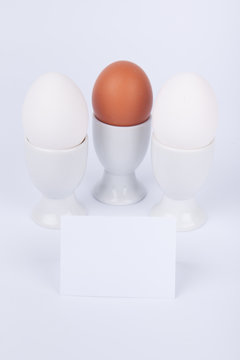 Drei Eier in Eierbecher mit Hinweisschild Hochformat