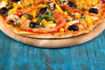 Tasty pizza on blue wooden table close-up