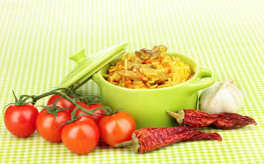 Delicious pilaf with vegetables on tablecloth background