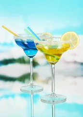  Gele en blauwe cocktails in glazen op blauwe natuurlijke achtergrond © Africa Studio
