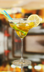 Yellow cocktail in glass on room background