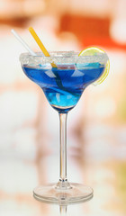 Blue cocktail in glass on room background