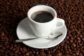 Cup of coffee on coffee beans background