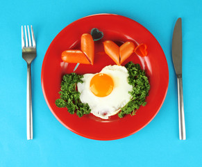 Sausages in form of hearts, scrambled eggs and parsley,