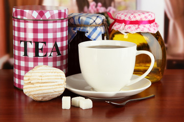 Jar and cup of tea on table in room