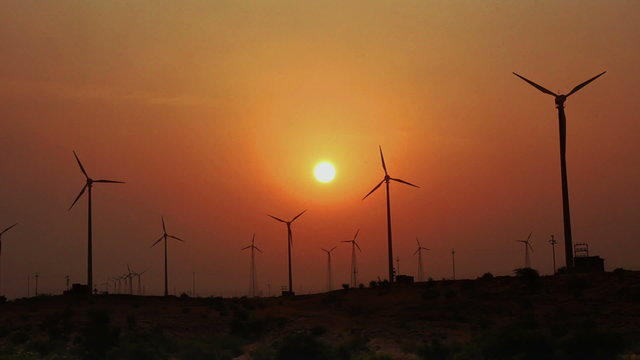 wind farm - turning windmills against timelapse sunset