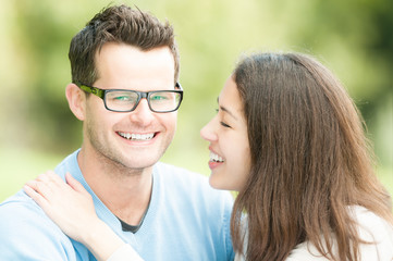 Portrait of happy young man and woman in park.