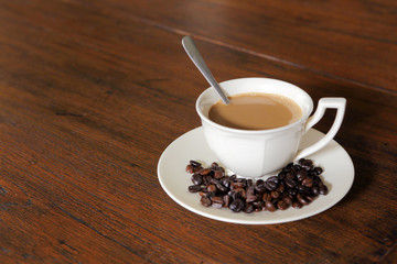 Coffee cup with Coffee Beans on grunge wood