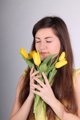 Beautiful long-haired romantic girl with yellow tulips
