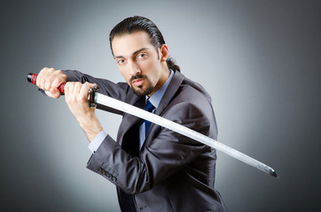 Angry businessman with sword in dark room © Elnur