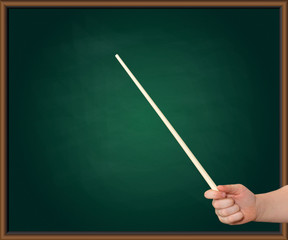 Hands of a child with a pointer on a green blackboard background