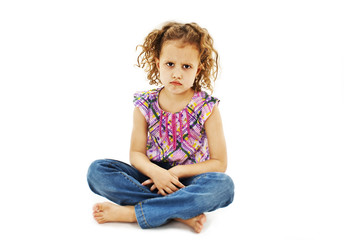 Sad curly little girl, sitting on white background