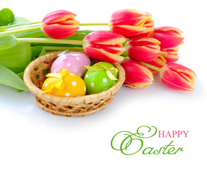 Fototapeta na wymiar Easter eggs in basket and bouquet of tulips are on white backgro