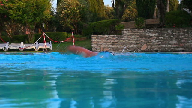 Young man swimming in pool.