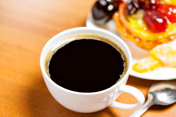 Cup of coffee and sweet fruit cake on a table