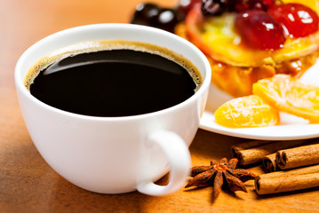 Cup of coffee and sweet fruit cake on a table