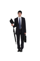 businessman holding an umbrella, a briefcase and a hat