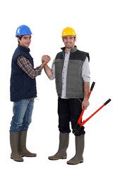 Two manual workers shaking hands