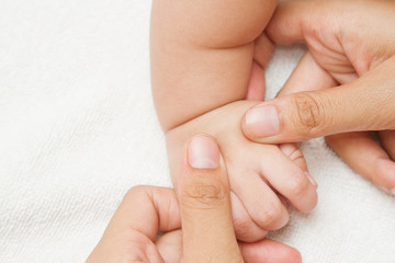 Mother massage and reflexology  hand of her baby,touch of Happin
