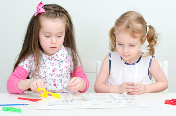 Two little girls sculpting using clay