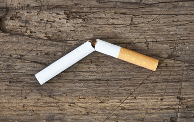 Zerbrochene Zigarette auf Holzplatte