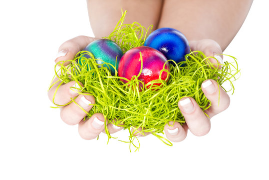 Frau im Osterhasenkost&uuml;m mit Ostereiern und Gras in der Hand