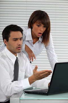 Two businessworkers shocked by laptop screen