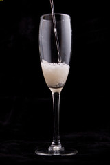 Glass with champagne on black