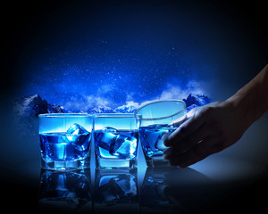 Three glasses of blue liquid with ice