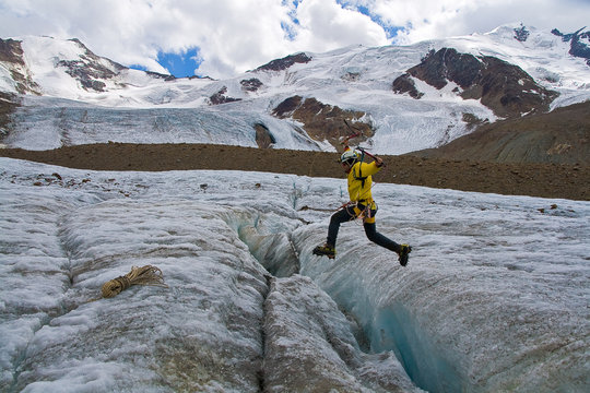 Alpinista che salta Crepaccio