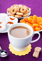 White cup of coffee with breakfast items on the lilac napkin