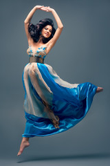 beautiful girl floating in mid-air, blue silk dress