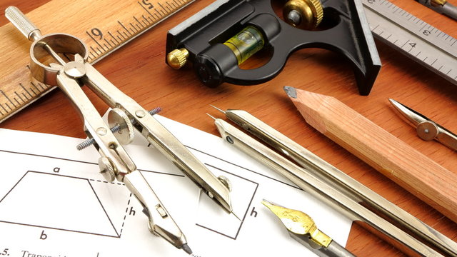 Vintage engineering and drafting tools on wood background.