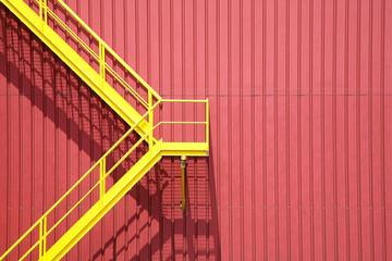 escalera amarilla sobre fachada de color rojo industria 9362f
