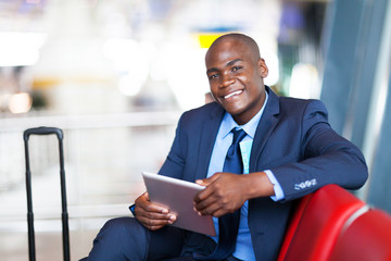 african business traveller using tablet computer at airport