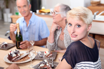 Family gathered around table eating cake