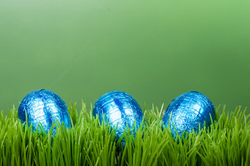 Three blue foil Easter eggs on grass