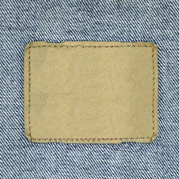 Blank leather jeans label sewed on a blue jeans.