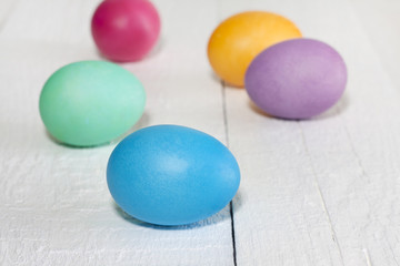 Colorful easter eggs on white wooden white planks