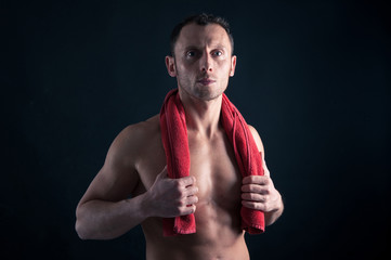 Confident young man shirtless portrait with red towel